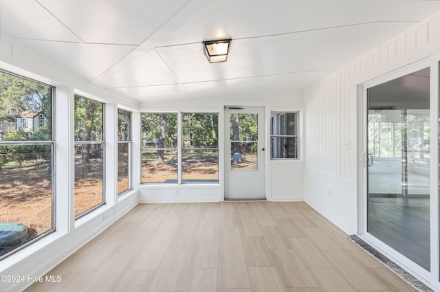 unfurnished sunroom featuring vaulted ceiling