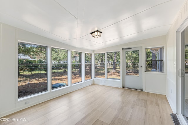 unfurnished sunroom featuring vaulted ceiling