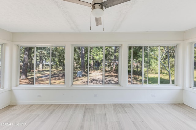 unfurnished sunroom with ceiling fan