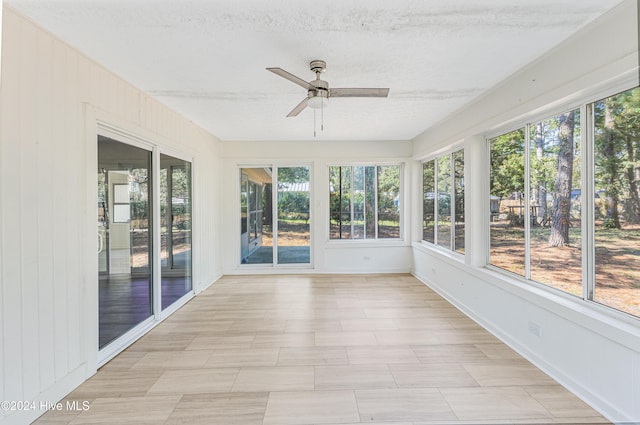 unfurnished sunroom with ceiling fan