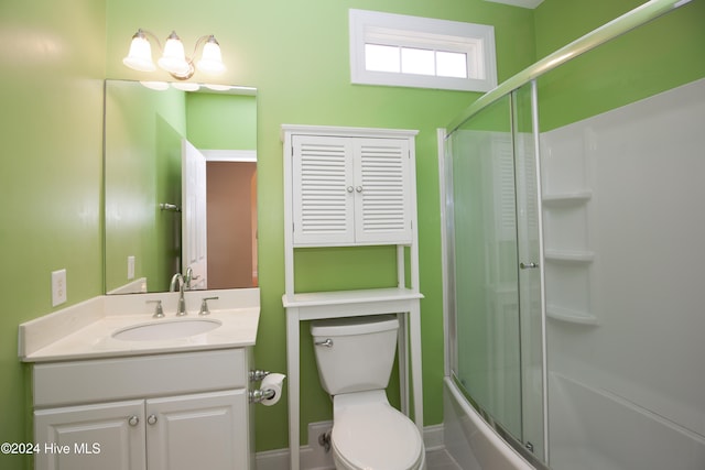 full bathroom with vanity, toilet, and bath / shower combo with glass door