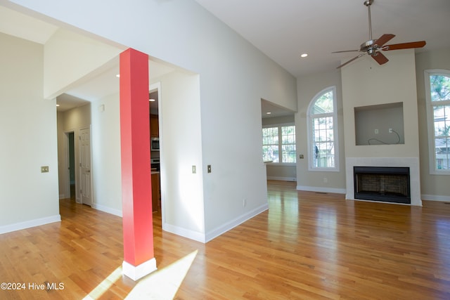 unfurnished living room with light hardwood / wood-style flooring and ceiling fan