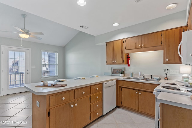 kitchen with white appliances, a peninsula, vaulted ceiling, light countertops, and a sink