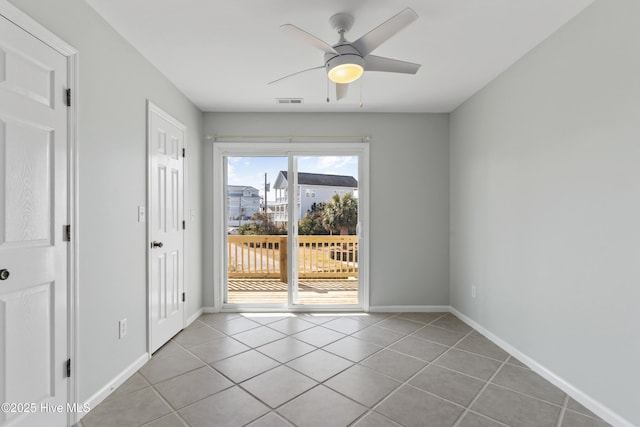 unfurnished room with ceiling fan, light tile patterned flooring, visible vents, and baseboards