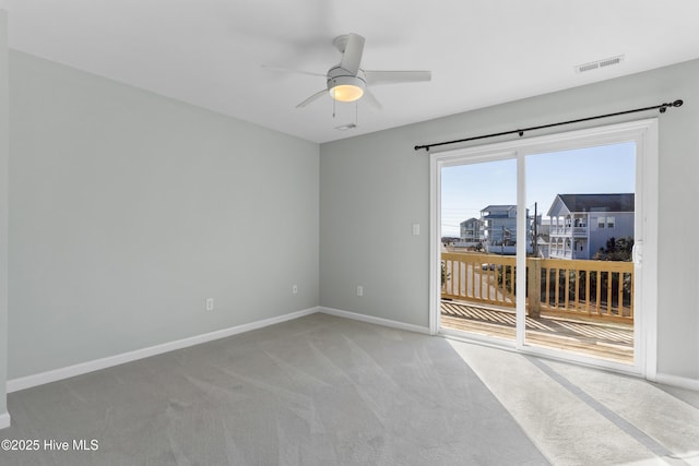 spare room with baseboards, ceiling fan, visible vents, and light colored carpet