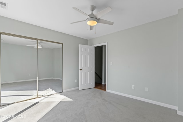 unfurnished bedroom featuring visible vents, baseboards, a ceiling fan, carpet floors, and a closet