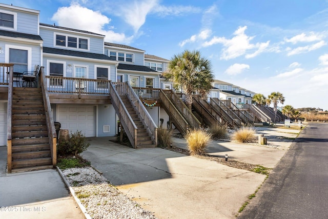 townhome / multi-family property featuring a residential view, driveway, an attached garage, and stairs