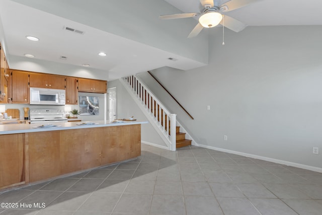 kitchen with light countertops, white appliances, visible vents, and baseboards