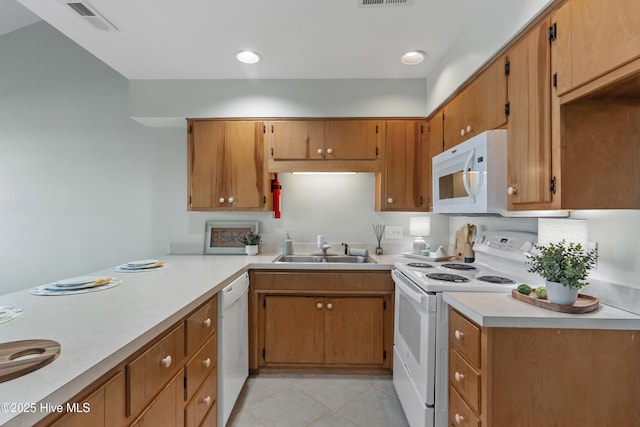 kitchen with light countertops, white appliances, a sink, and visible vents