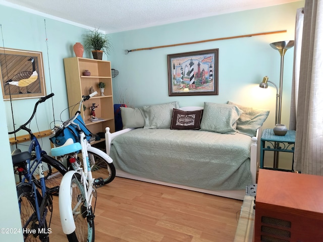 bedroom featuring light hardwood / wood-style flooring and a textured ceiling