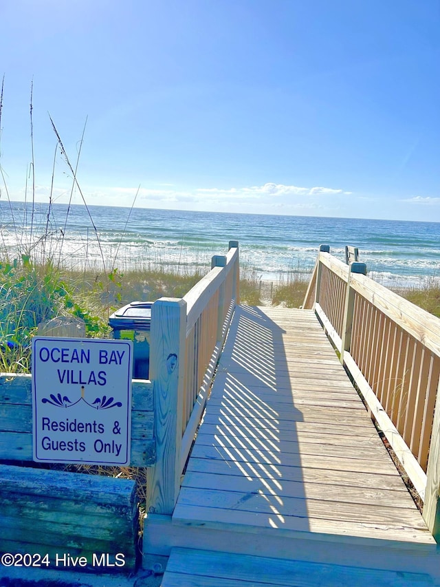 view of property's community with a water view and a beach view