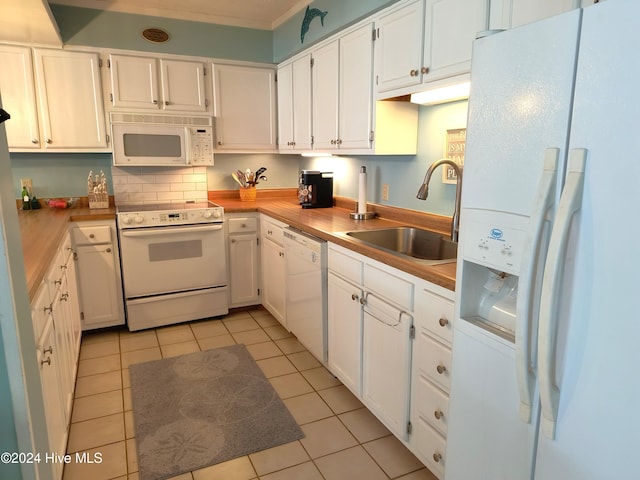 kitchen with white cabinets, backsplash, light tile patterned flooring, sink, and white appliances