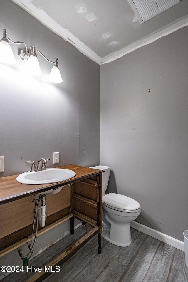 bathroom featuring hardwood / wood-style flooring, sink, crown molding, and toilet