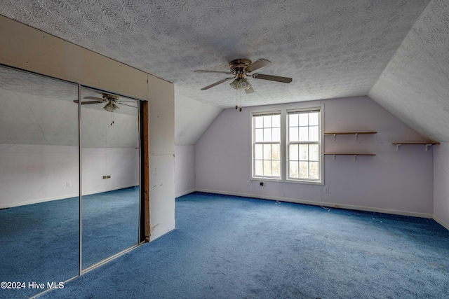 additional living space with carpet, a textured ceiling, vaulted ceiling, and ceiling fan