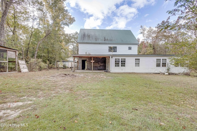 back of property with a lawn and a patio