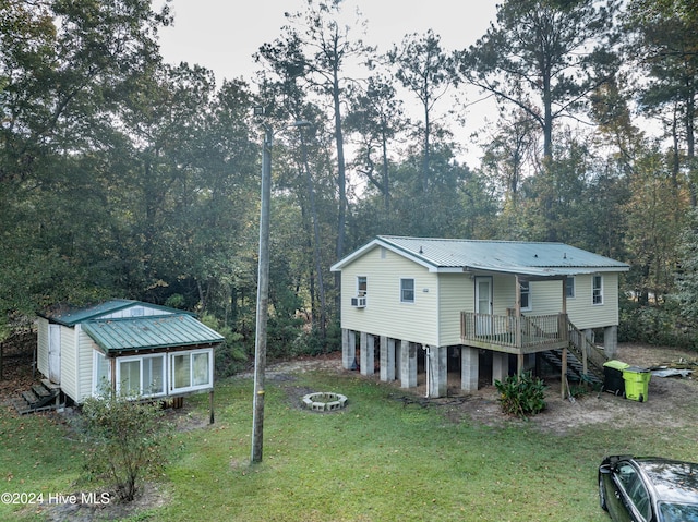 back of property with a deck, a storage shed, and a lawn