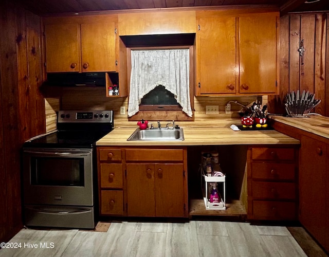 kitchen featuring sink, light hardwood / wood-style flooring, stainless steel electric range oven, butcher block countertops, and extractor fan