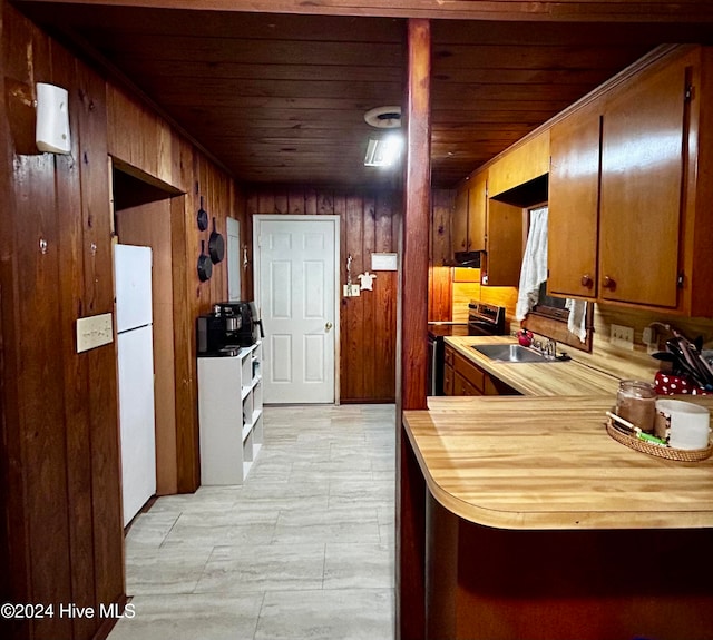 kitchen featuring white refrigerator, stainless steel electric range oven, wooden ceiling, and sink