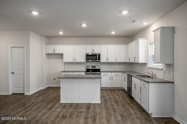 3057 Platinum Cir W, End, NC 27376 - kitchen with appliances with stainless steel finishes, a sink, dark stone countertops, backsplash, and dark wood-style flooring