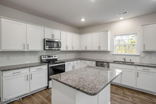 3057 Platinum Cir W, End, NC 27376 - kitchen featuring stainless steel appliances, white cabinets, decorative backsplash, a sink, and stone countertops