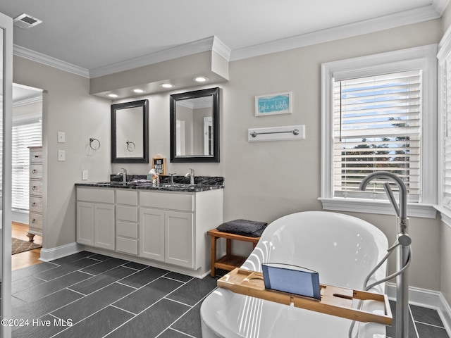 2610 Emerald Dr, Emerald Isle, NC 28594 - bathroom featuring crown molding, a freestanding bath, baseboards, double vanity, and tile patterned floors
