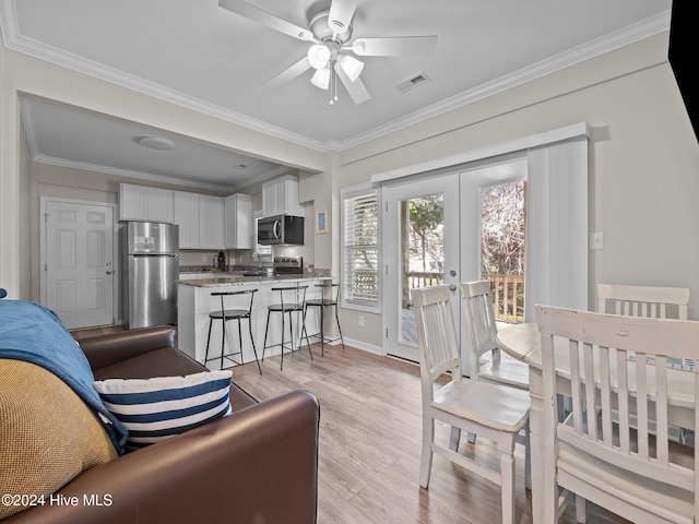 interior space featuring light hardwood / wood-style floors, ceiling fan, crown molding, and french doors