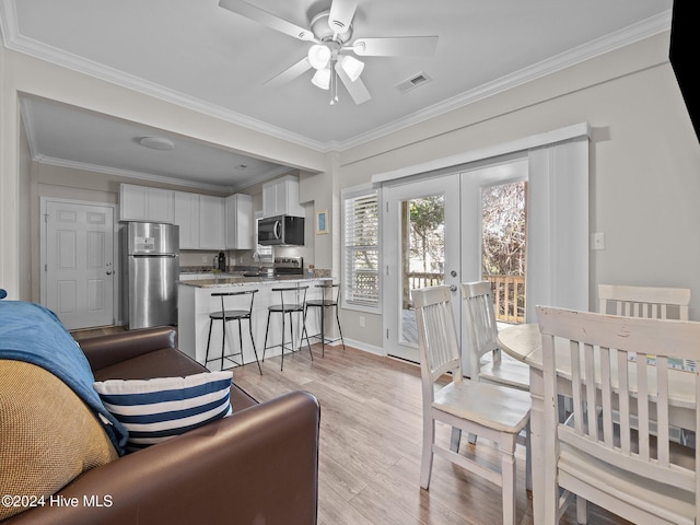 2610 Emerald Dr, Emerald Isle, NC 28594 - living room with light wood-style flooring, ceiling fan, crown molding, french doors, and baseboards