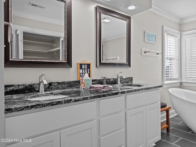 bathroom with vanity, tile patterned flooring, ornamental molding, and a bathing tub