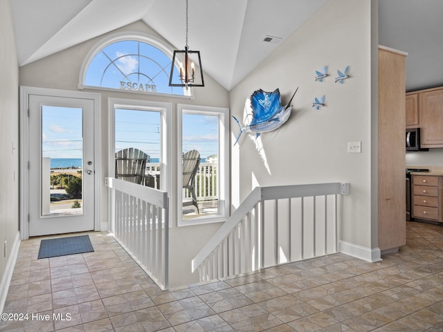 2610 Emerald Dr, Emerald Isle, NC 28594 - foyer entrance featuring lofted ceiling, a chandelier, baseboards, and stone finish flooring