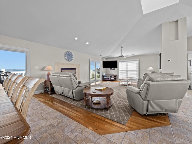 living room featuring lofted ceiling, ceiling fan, and light hardwood / wood-style flooring