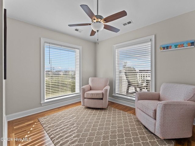 living area with hardwood / wood-style flooring, ceiling fan, and plenty of natural light