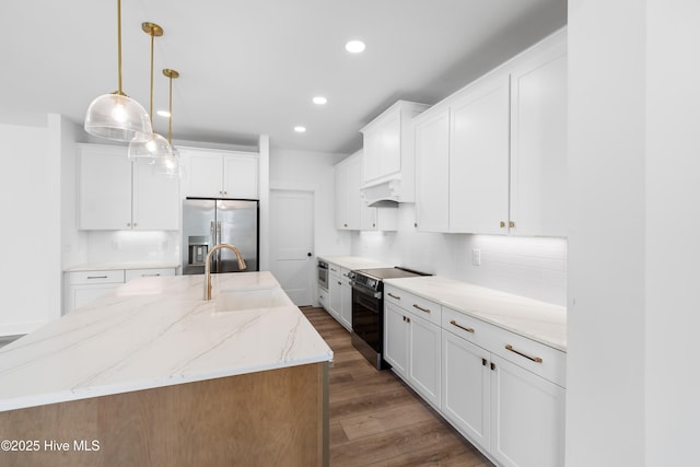 kitchen with stainless steel appliances, an island with sink, and white cabinetry