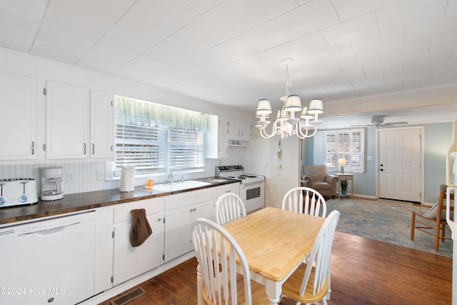 dining room featuring ceiling fan with notable chandelier, dark wood-type flooring, and sink