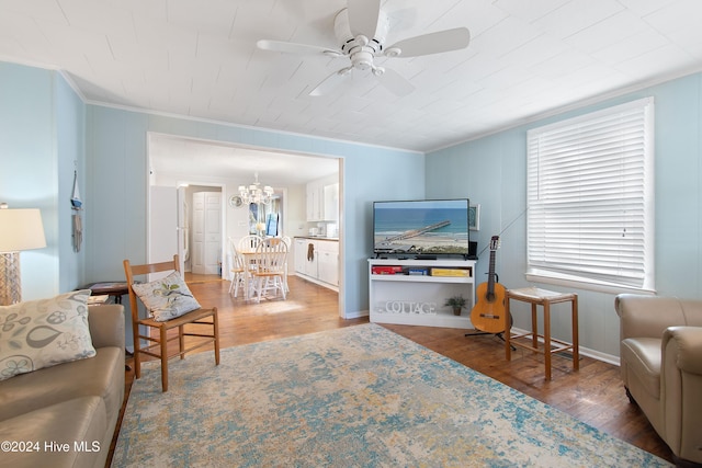 living room with crown molding, hardwood / wood-style floors, and ceiling fan with notable chandelier