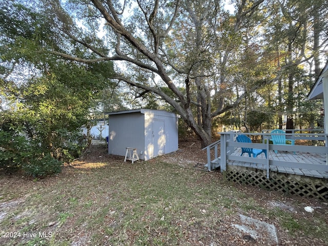 view of yard featuring a storage shed and a wooden deck