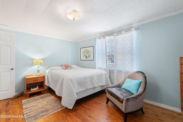 bedroom featuring wood-type flooring and ornamental molding