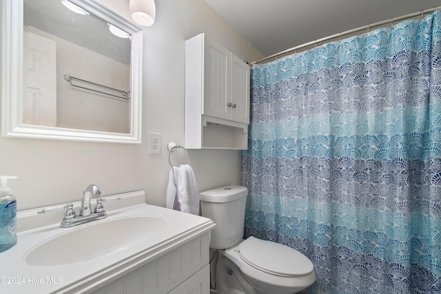 bathroom featuring vanity, toilet, and walk in shower