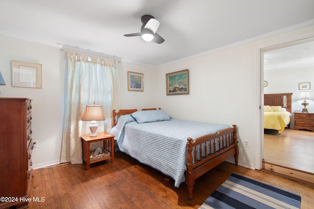 bedroom with dark wood-type flooring, ceiling fan, and crown molding