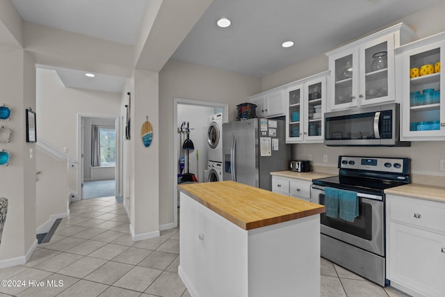 kitchen featuring white cabinetry, appliances with stainless steel finishes, stacked washer / drying machine, and a kitchen island