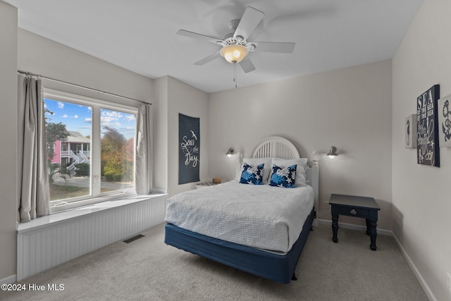 bedroom featuring radiator heating unit, light carpet, and ceiling fan