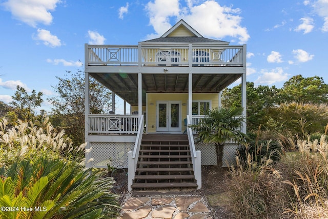 raised beach house featuring french doors and a deck