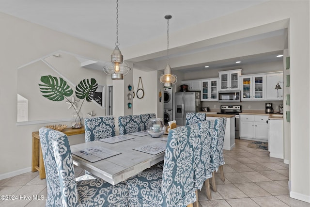 tiled dining space with stacked washing maching and dryer