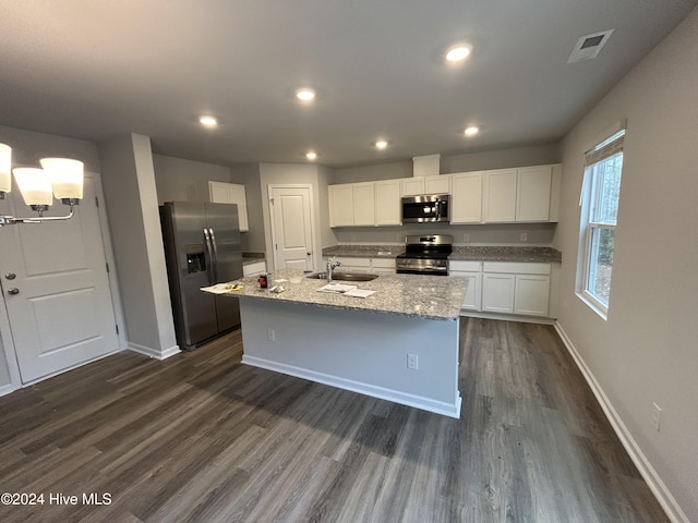 kitchen with an island with sink, appliances with stainless steel finishes, dark hardwood / wood-style flooring, white cabinets, and sink