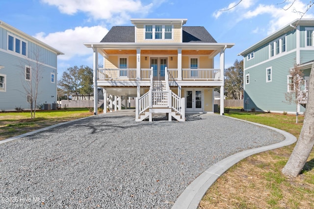 view of front of house featuring a front lawn, french doors, covered porch, a carport, and central AC unit