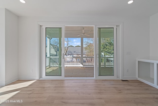 doorway to outside featuring ceiling fan and light wood-type flooring