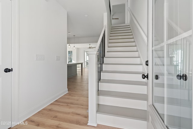 stairway with wood-type flooring, ceiling fan, and a wealth of natural light