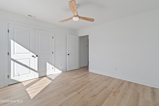 unfurnished bedroom with ceiling fan, light hardwood / wood-style flooring, and a closet