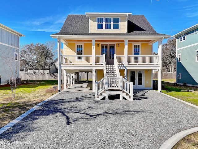 raised beach house featuring a porch, french doors, and a carport