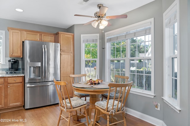 kitchen with ceiling fan, light stone countertops, light wood-type flooring, and stainless steel fridge