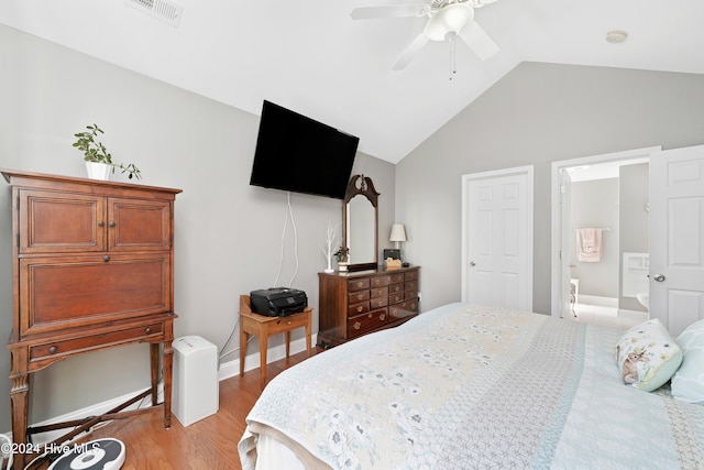 bedroom featuring connected bathroom, vaulted ceiling, light wood-type flooring, and ceiling fan